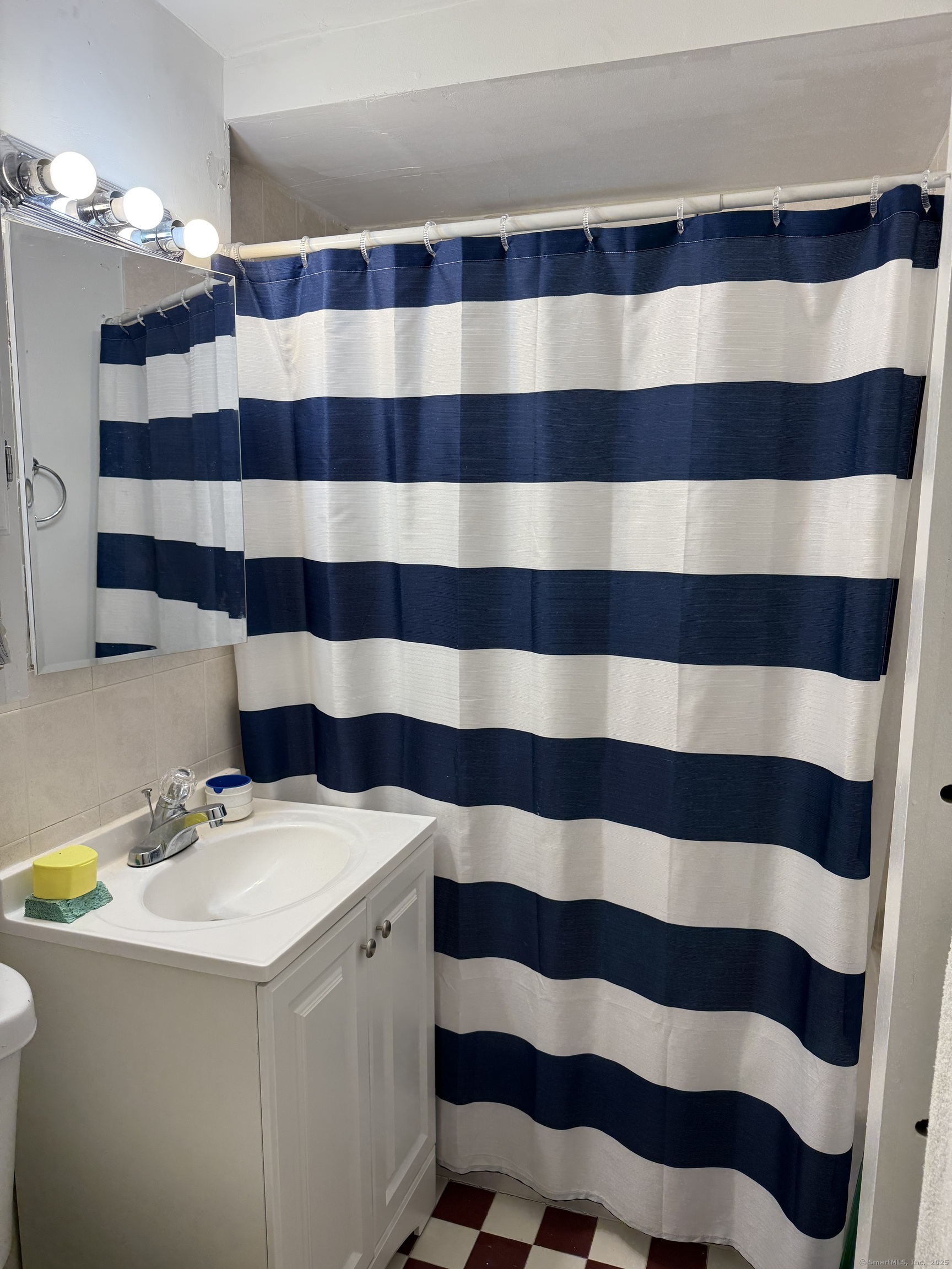 84 Canaan Court, Unit 11 Stratford, CT 06614 - Photo 12 of 13 a bathroom with a sink and a mirror