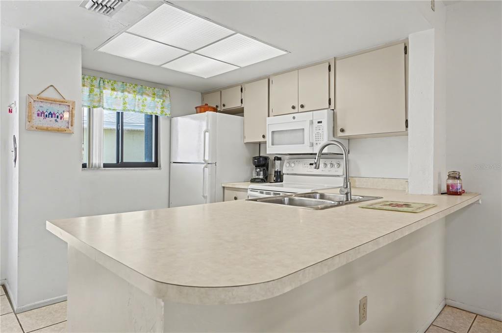 25225 Rampart Boulevard, Unit 1606 Punta Gorda, FL 33983 - Photo 18 of 34 a kitchen with stainless steel appliances granite countertop a sink a stove and a refrigerator