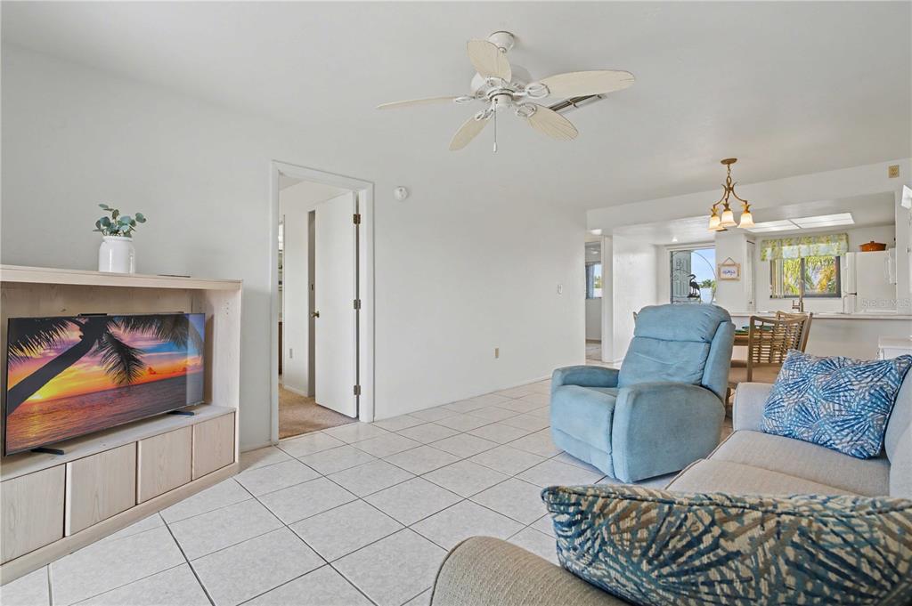 25225 Rampart Boulevard, Unit 1606 Punta Gorda, FL 33983 - Photo 23 of 34 a living room with furniture a rug and a chandelier