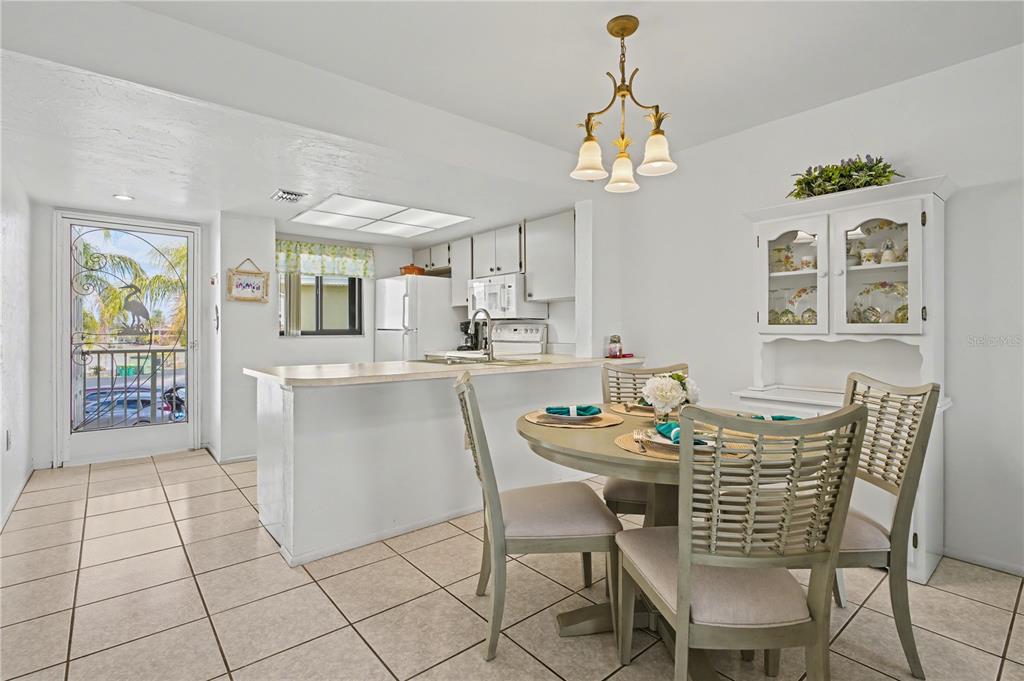 25225 Rampart Boulevard, Unit 1606 Punta Gorda, FL 33983 - Photo 7 of 34 a dining room filled chandelier and kitchen view