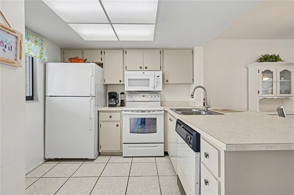 25225 Rampart Boulevard, Unit 1606 Punta Gorda, FL 33983 - Photo 8 of 34 a kitchen with a white stove top oven and white refrigerator