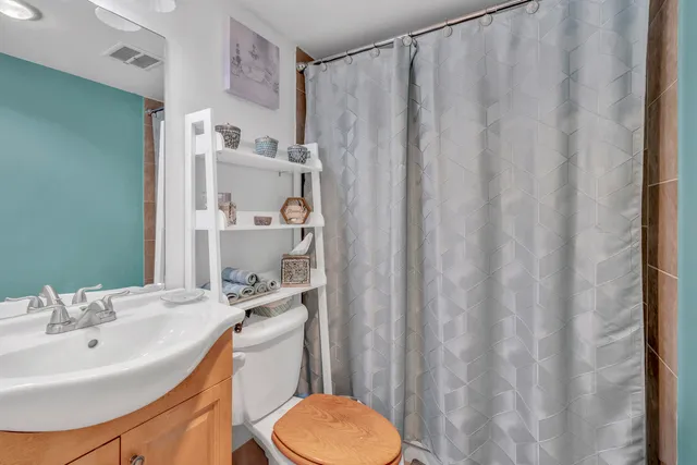a bathroom with a sink a toilet and shower curtain