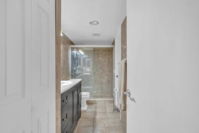 a bathroom with a glass door shower a sink and a mirror