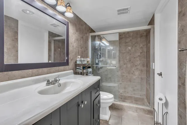 a bathroom with a sink toilet a mirror and shower