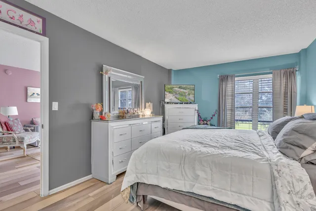 a bedroom with a bed and a dresser next to a window