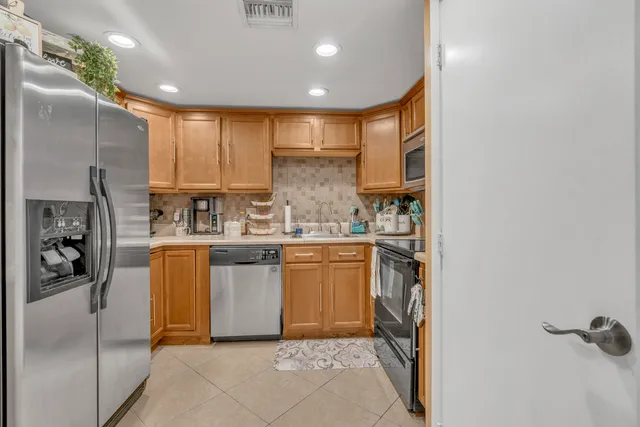 a kitchen with a refrigerator and white cabinets