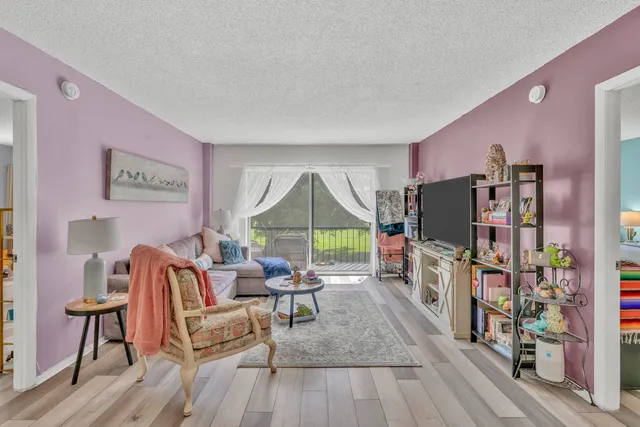 a living room with furniture a flat screen tv and a floor to ceiling window