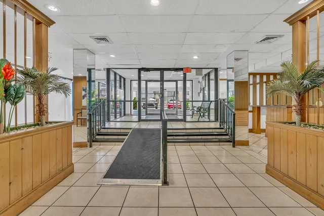 a hallway with a black white checkered floor and next to a window