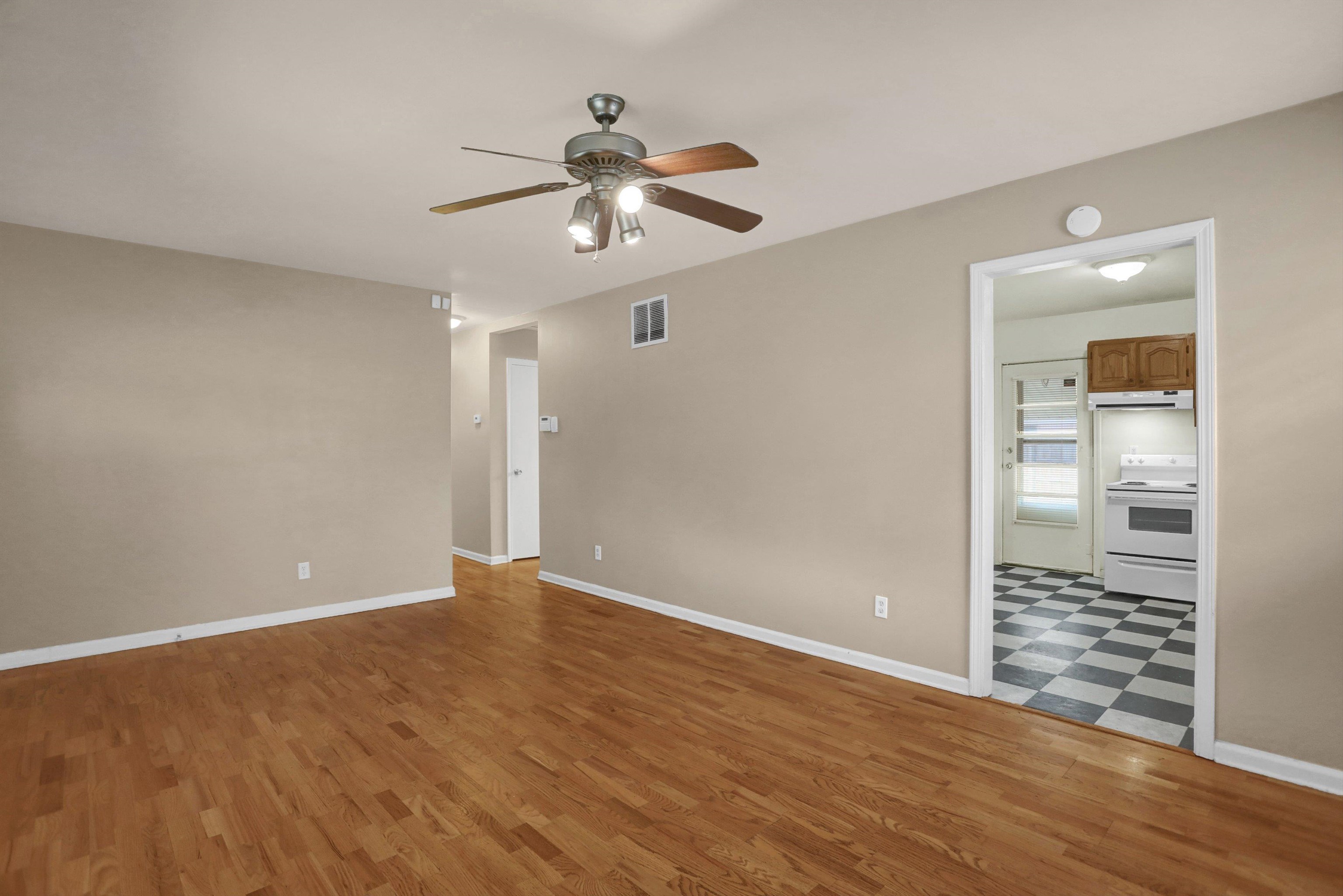 381 Mineral Road Memphis, TN 38120 - Photo 3 of 14 a view of an empty room with wooden floor and a ceiling fan