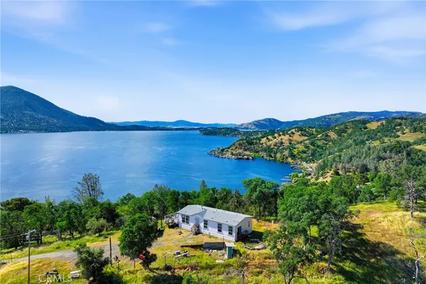 an aerial view of a house with a garden and lake view