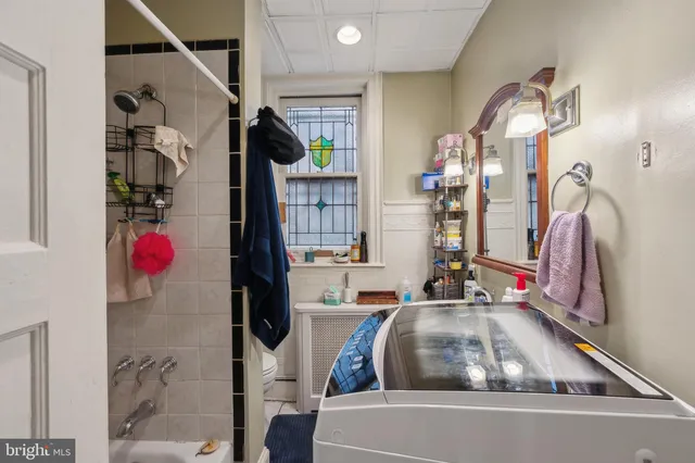 a living room with furniture a dining table and a refrigerator