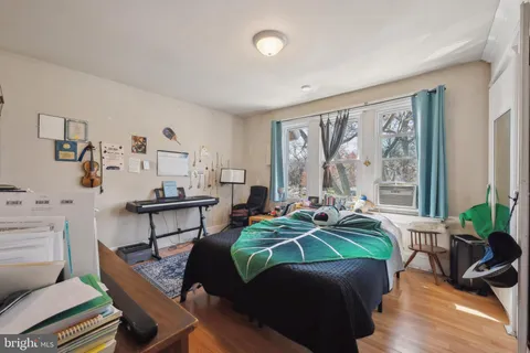 a bedroom with a bed and wooden floor