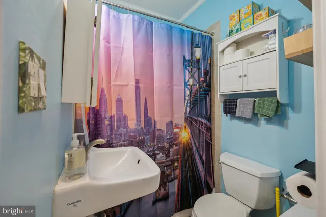 a view of a brick house with a small yard and wooden fence