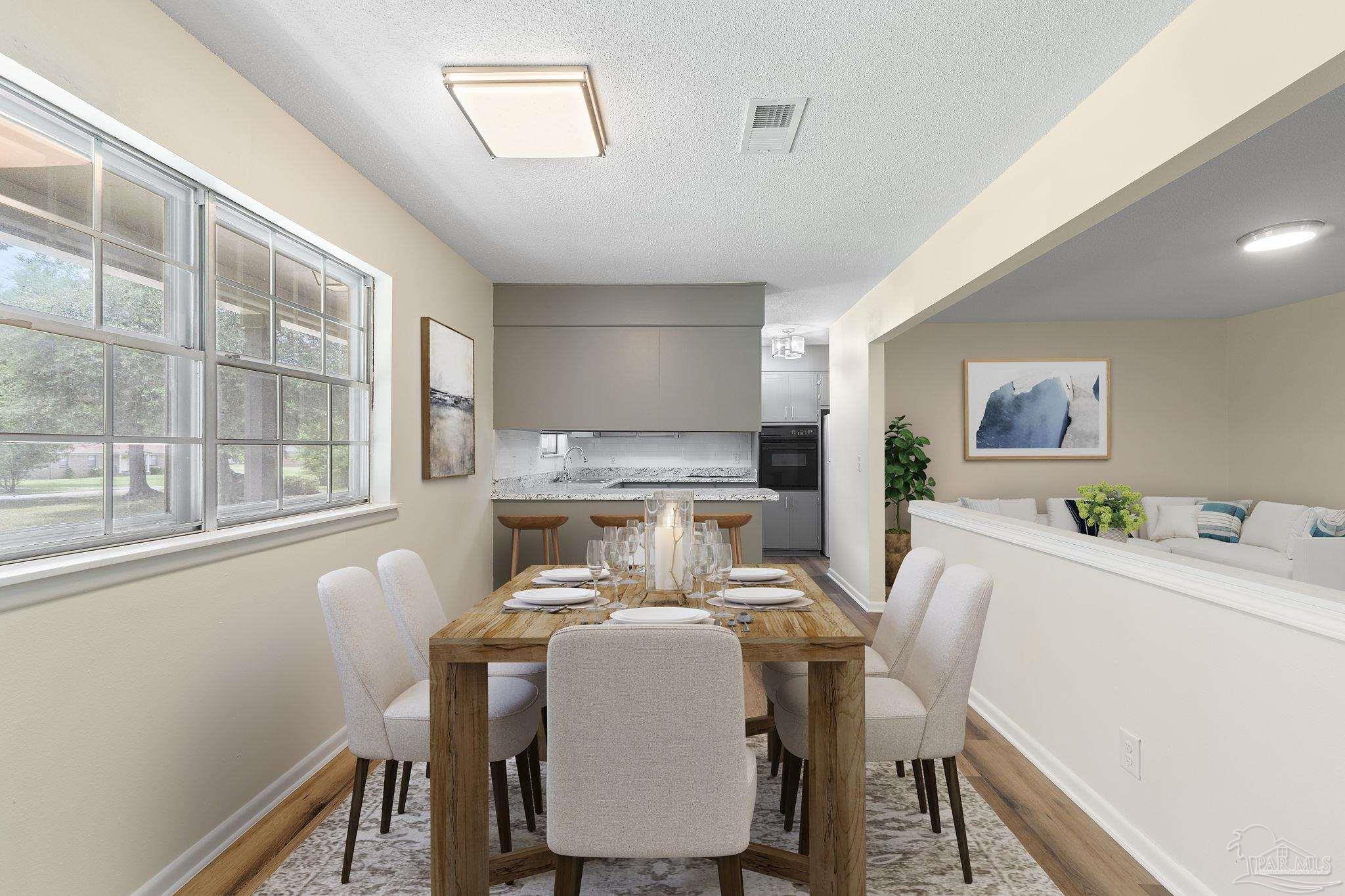 6472 Sandy Lane Milton, FL 32570 - Photo 12 of 51 a view of a dining room with furniture window and wooden floor