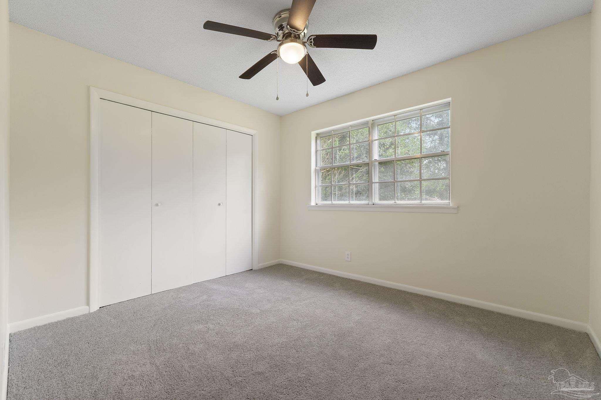 6472 Sandy Lane Milton, FL 32570 - Photo 23 of 51 an empty room with a window and a fan