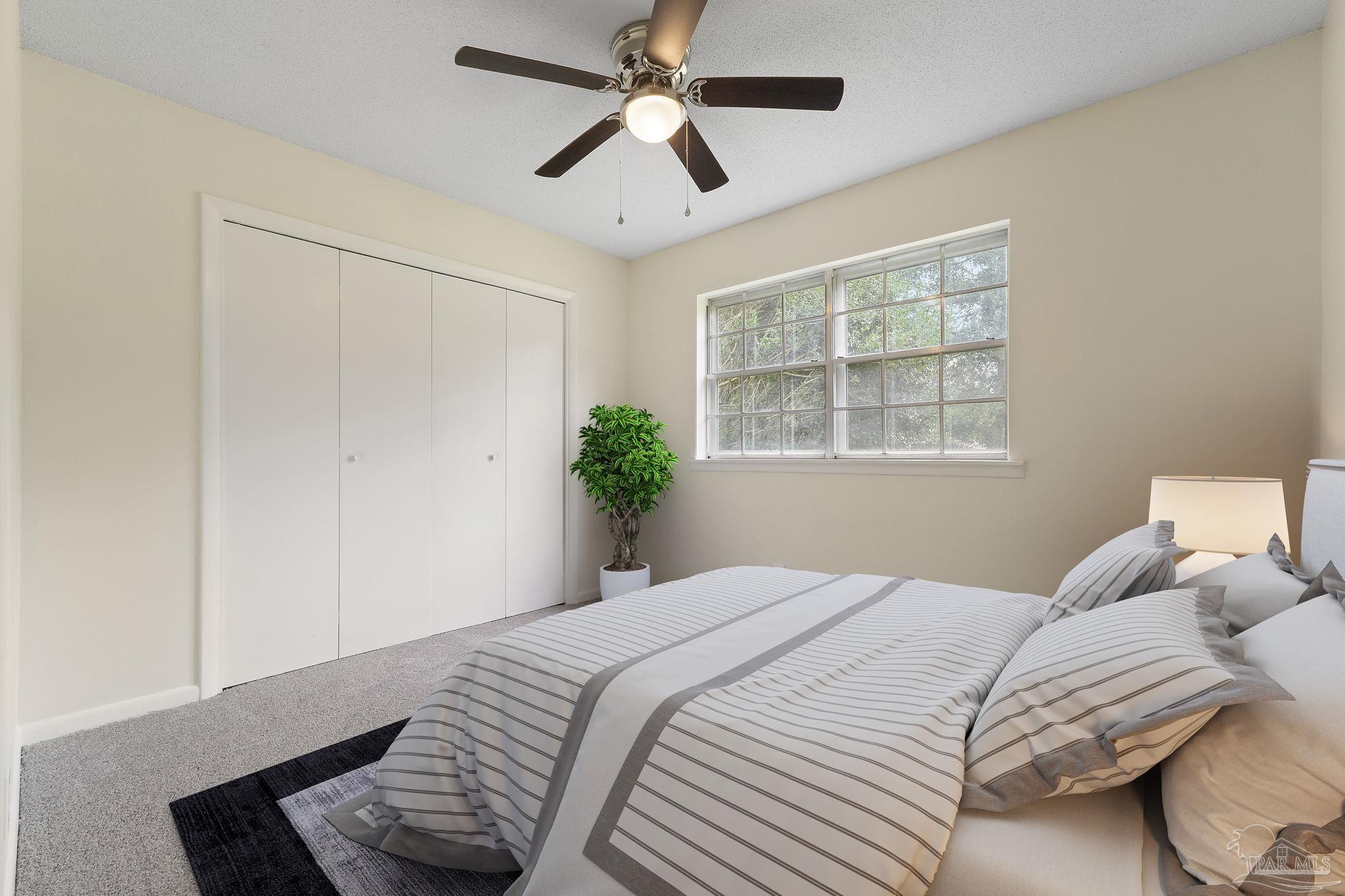 6472 Sandy Lane Milton, FL 32570 - Photo 24 of 51 a bedroom with a large bed and a chandelier fan