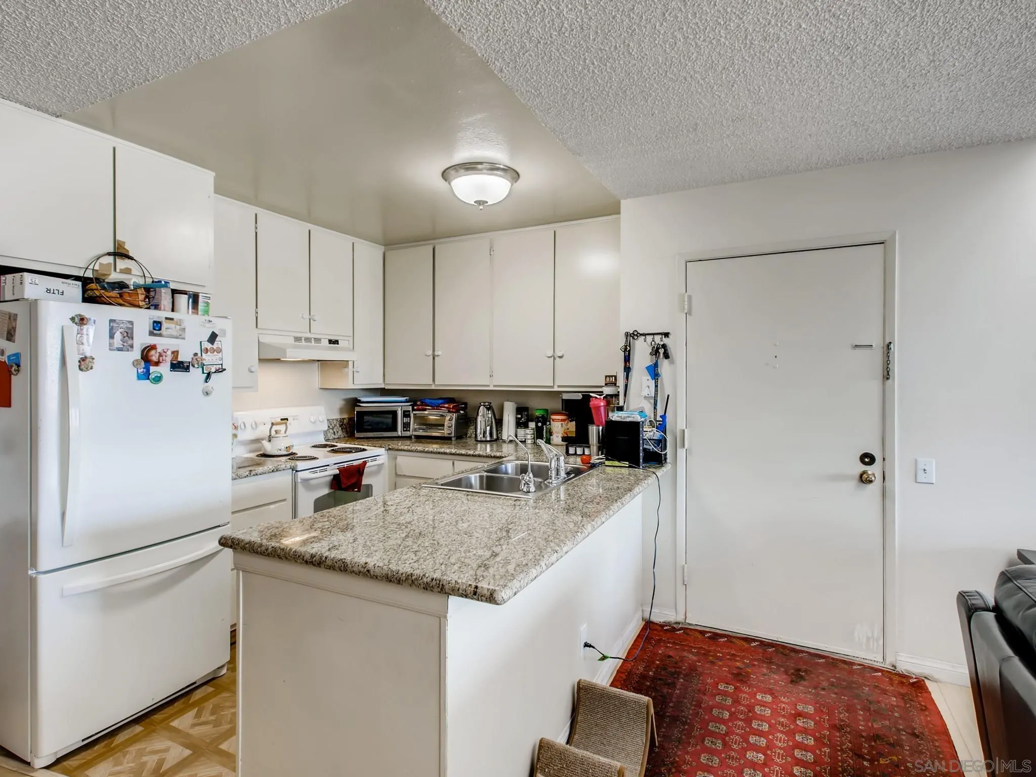 3550 Ruffin Road, Unit 239 San Diego, CA 92123 - Photo 12 of 27 a kitchen with refrigerator and cabinets
