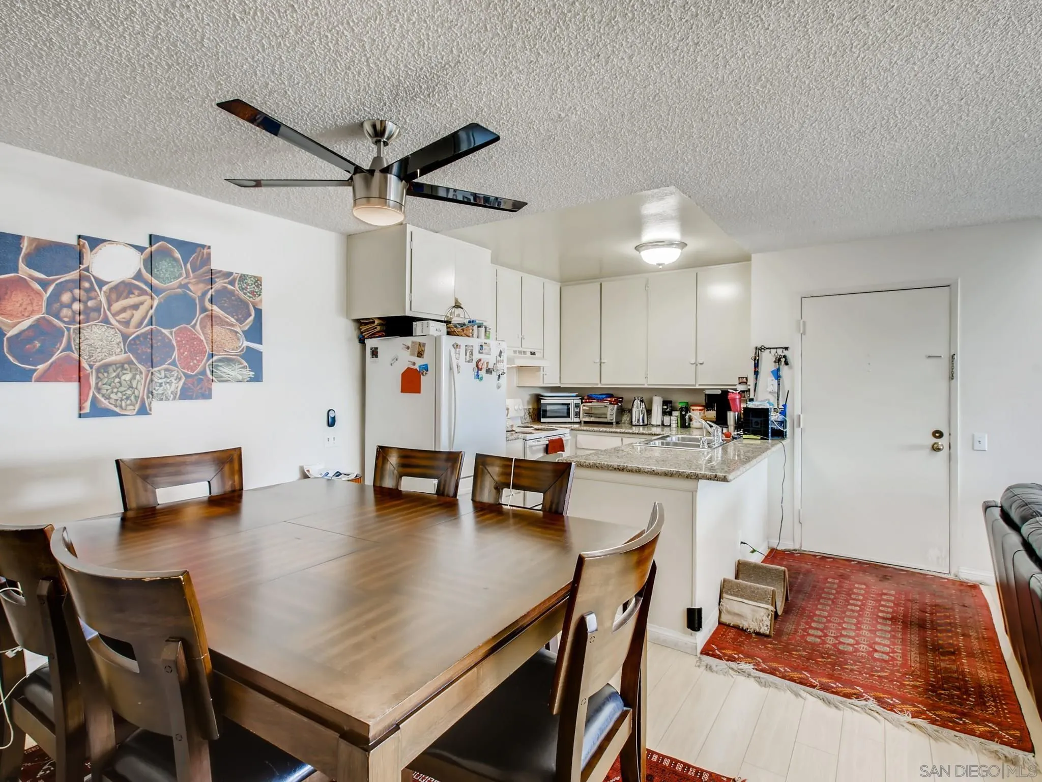 3550 Ruffin Road, Unit 239 San Diego, CA 92123 - Photo 13 of 27 a kitchen with a table chairs refrigerator and dining table