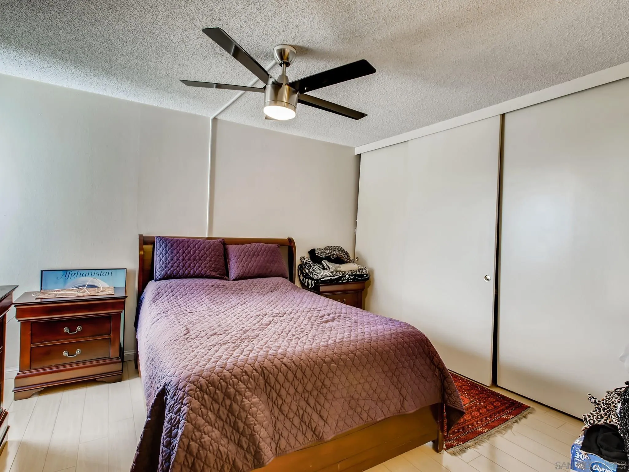 3550 Ruffin Road, Unit 239 San Diego, CA 92123 - Photo 15 of 27 a bedroom with a bed and a ceiling fan
