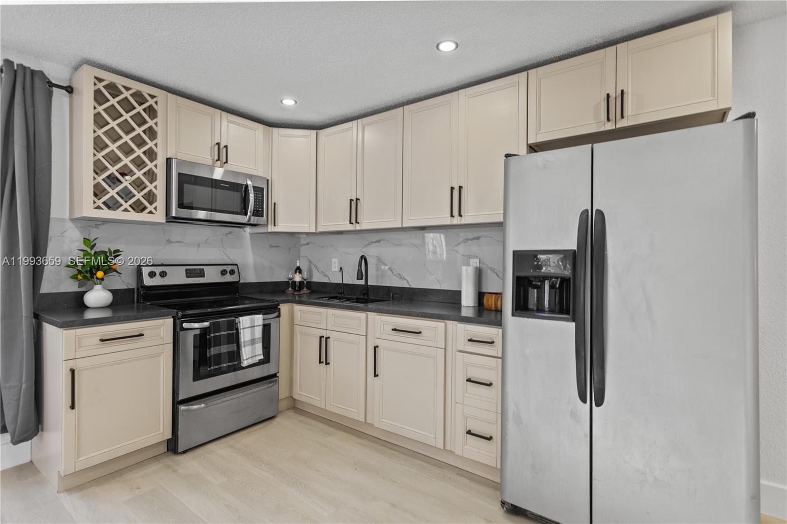 171 West 13th Street Hialeah, FL 33010 - Photo 17 of 84 a kitchen with stainless steel appliances granite countertop white cabinets a stove a microwave a sink and a refrigerator