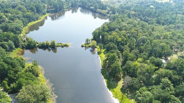 an aerial view of a house with a yard and lake view