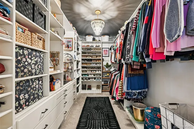 a view of walk in closet with clothes and shoes
