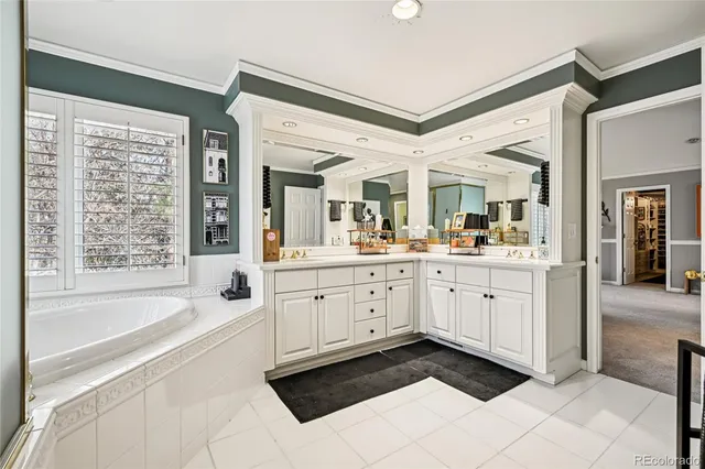 a spacious en suite bathroom with a granite countertop tub and a sink