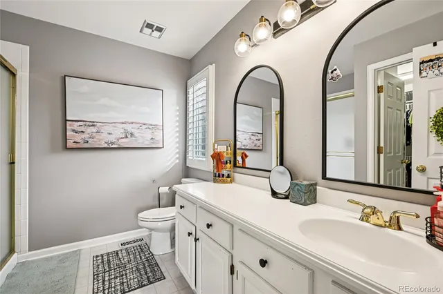 a bathroom with a double vanity sink mirror and toilet