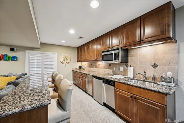 a kitchen with stainless steel appliances granite countertop a sink refrigerator stove and microwave