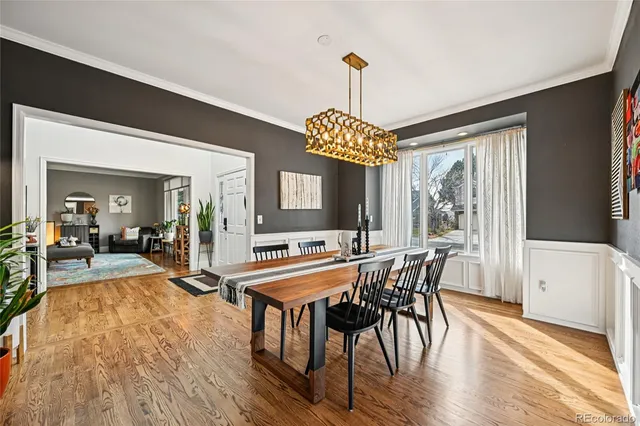 a dining room with furniture a chandelier and wooden floor