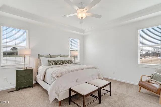 a bedroom with a bed a couch and a chandelier
