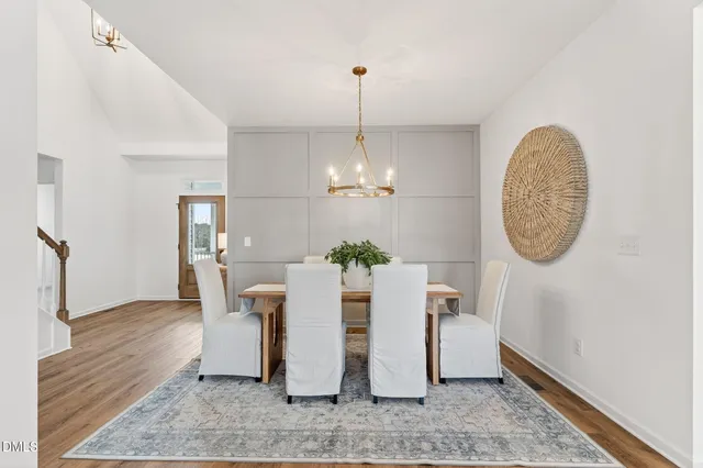 a view of a dining room with furniture a chandelier and wooden floor