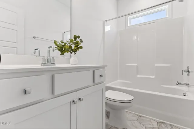 an empty room with chandelier fan and windows