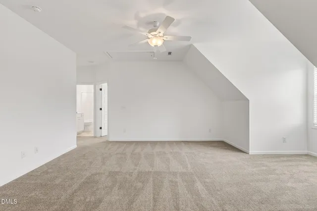 an empty room with windows and a ceiling fan