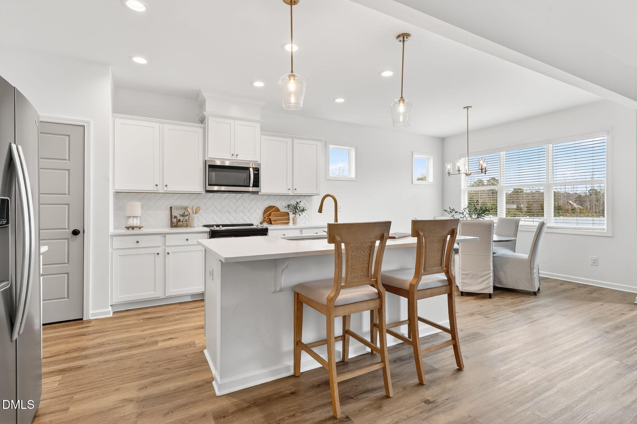 18 North Bream Court Angier, NC 27501 - Photo 6 of 49 a kitchen with a table chairs refrigerator and microwave