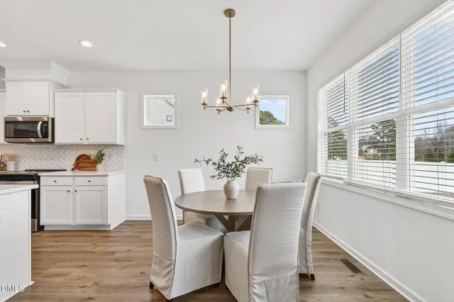 a view of a dining room with furniture a chandelier and wooden floor