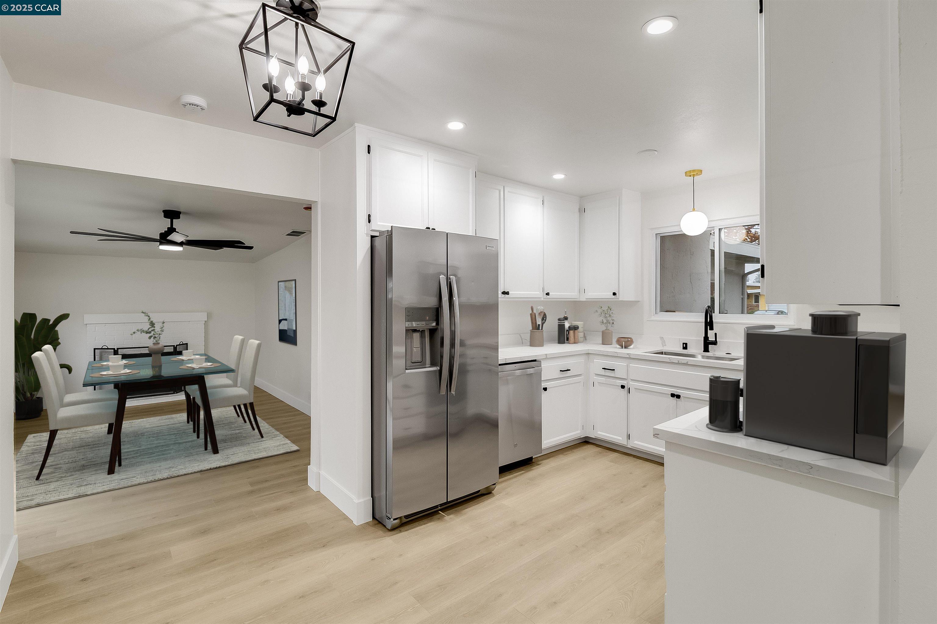 1863 San Clemente Street Fairfield, CA 94533 - Photo 9 of 29 a kitchen with stainless steel appliances a refrigerator a sink dishwasher a stove and a dining table with wooden floor