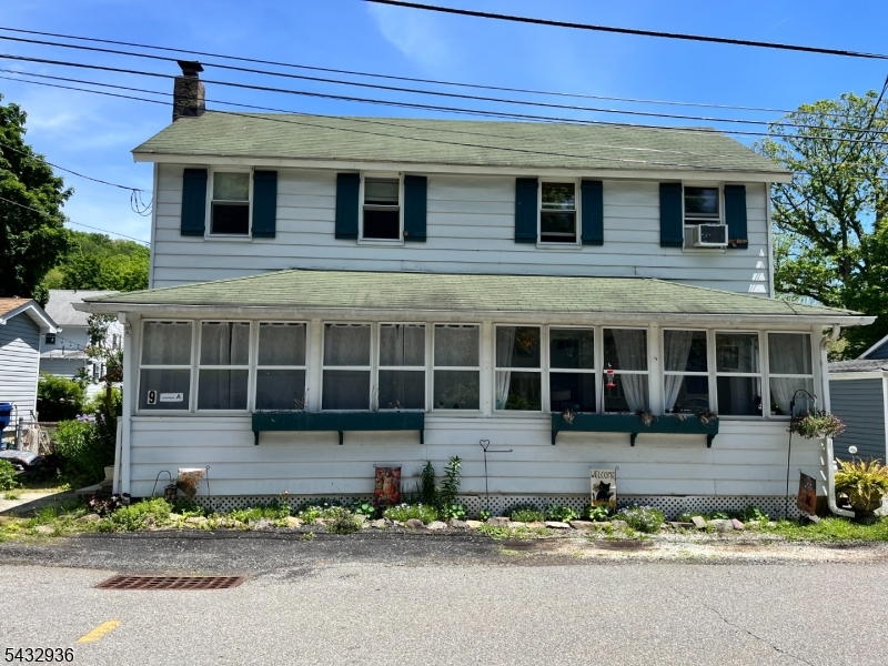9 New Row Road, Unit A Hibernia, NJ 07842 - Photo 1 of 18 a front view of a house with a yard and a garage