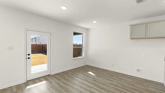 an empty room with wooden floor and mirror