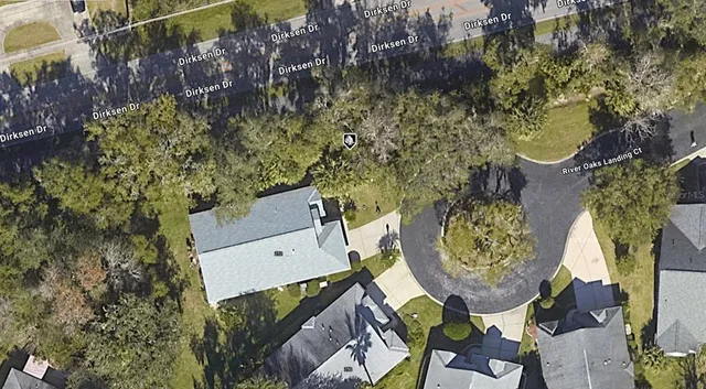an aerial view of a house with garden space and trees
