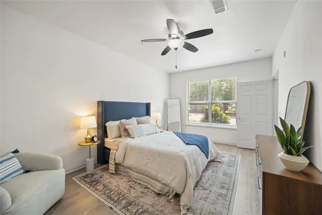 a bedroom with a bed a couch and a potted plant