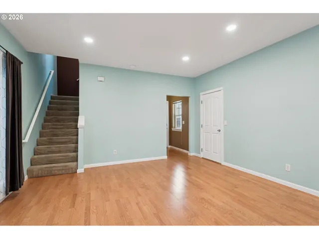 a view of an empty room with wooden floor