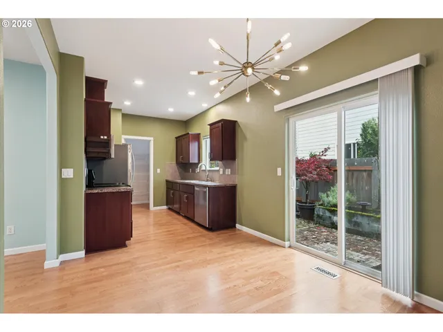 a kitchen with stainless steel appliances kitchen island granite countertop a refrigerator and a sink
