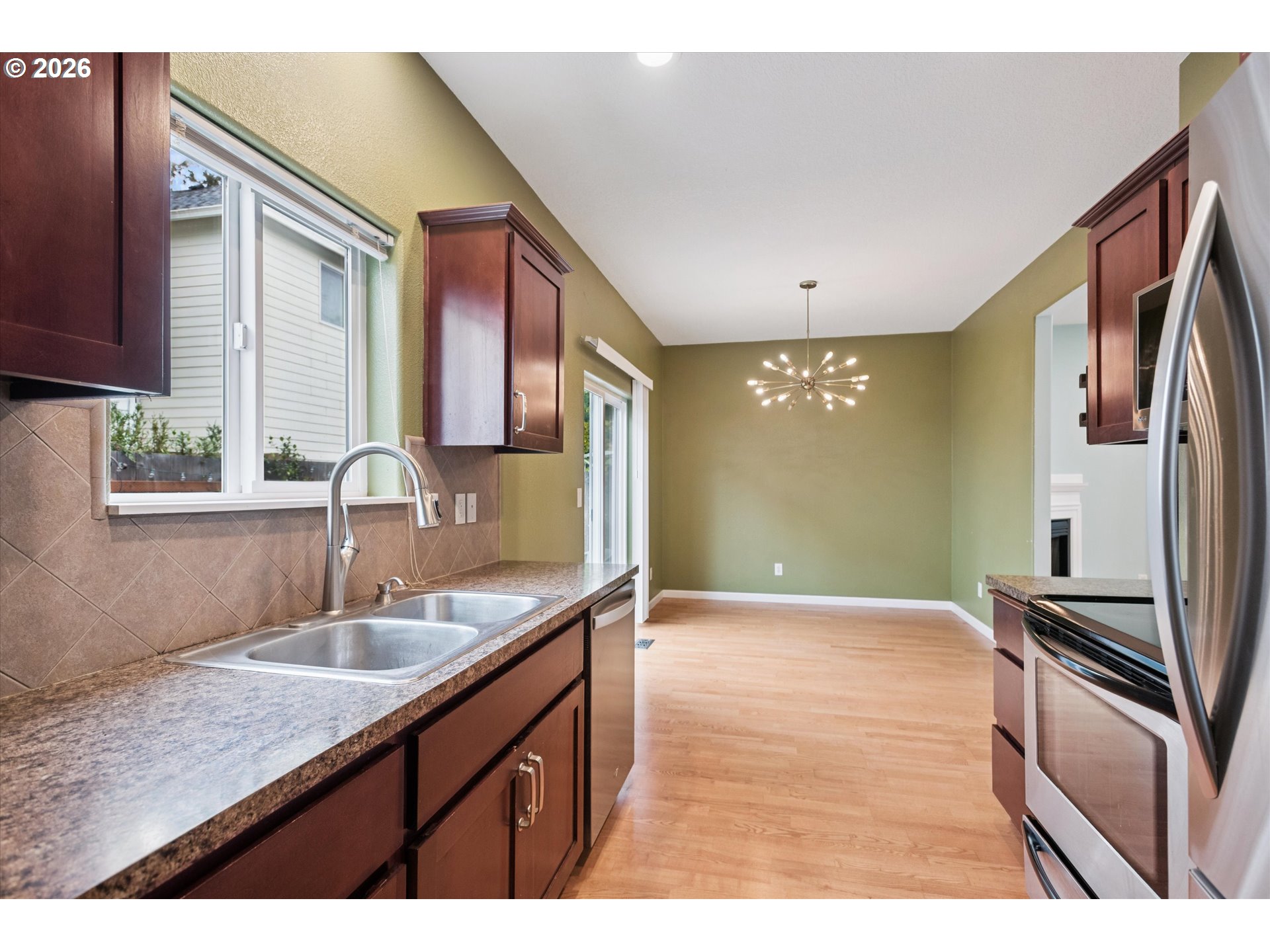 18232 Southwest Orlov Court Beaverton, OR 97078 - Photo 10 of 17 a kitchen with granite countertop a sink and cabinets