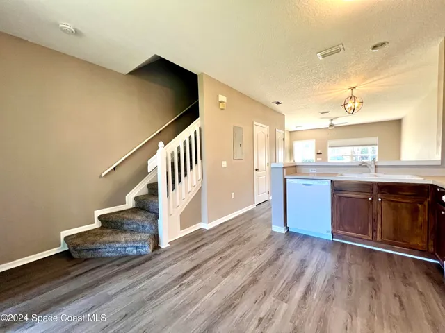 a view of kitchen with wooden floor and electronic appliances