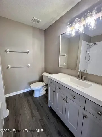 a bathroom with a granite countertop sink a toilet and a mirror