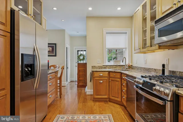 a kitchen with stainless steel appliances granite countertop a stove a refrigerator and a sink