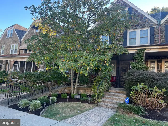 a front view of a house with plants and trees