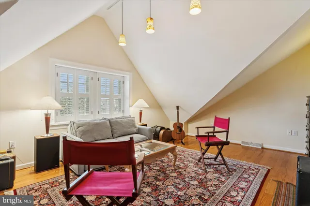 a bathroom with a granite countertop toilet a sink a mirror and a window