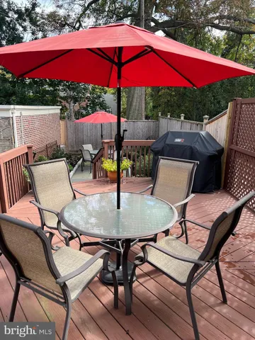 a view of a blue house with a yard and lawn chairs with wooden fence